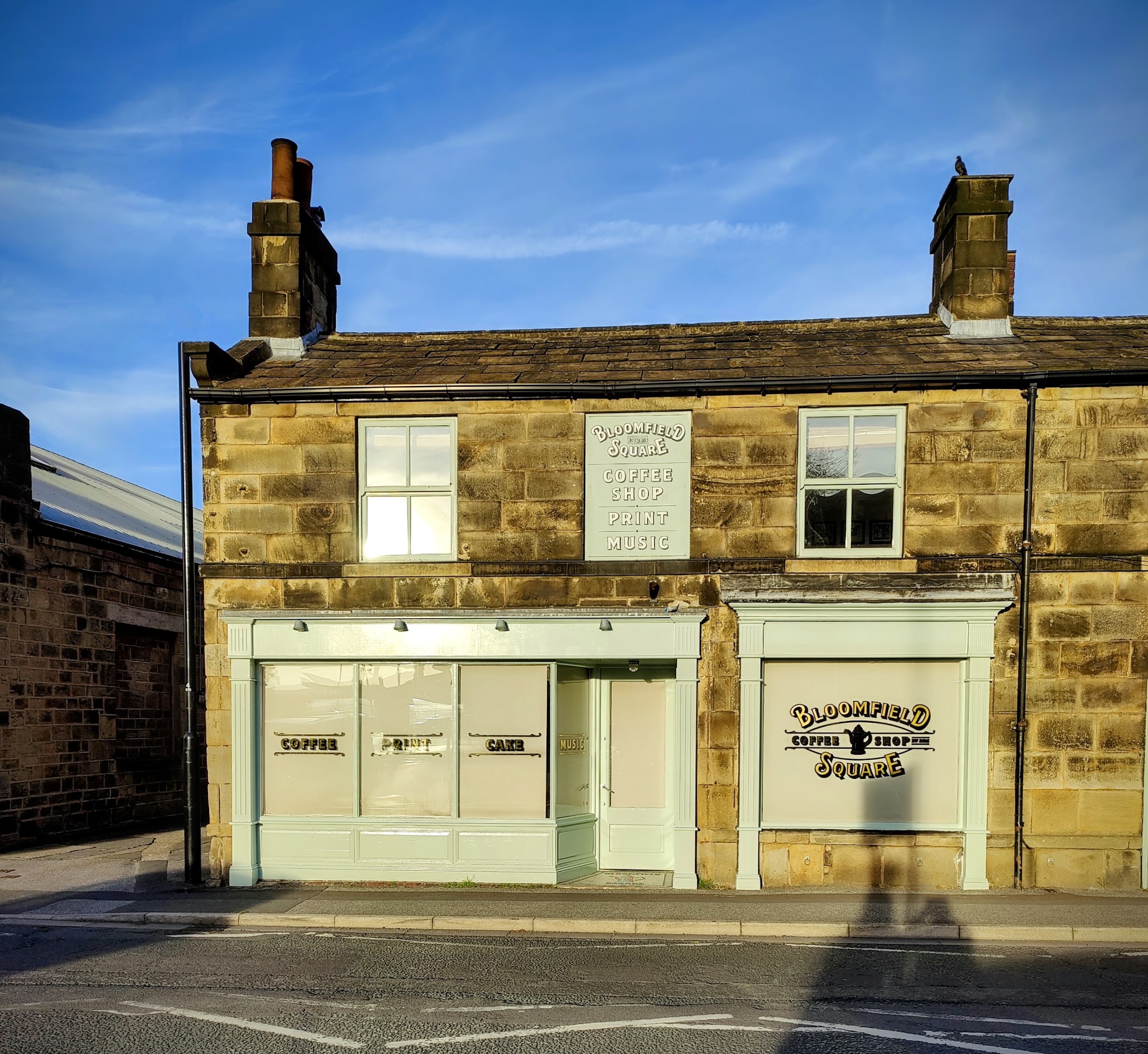 Bloomfield Square's stone shopfront and pale green windows on Gay Lane, Otley