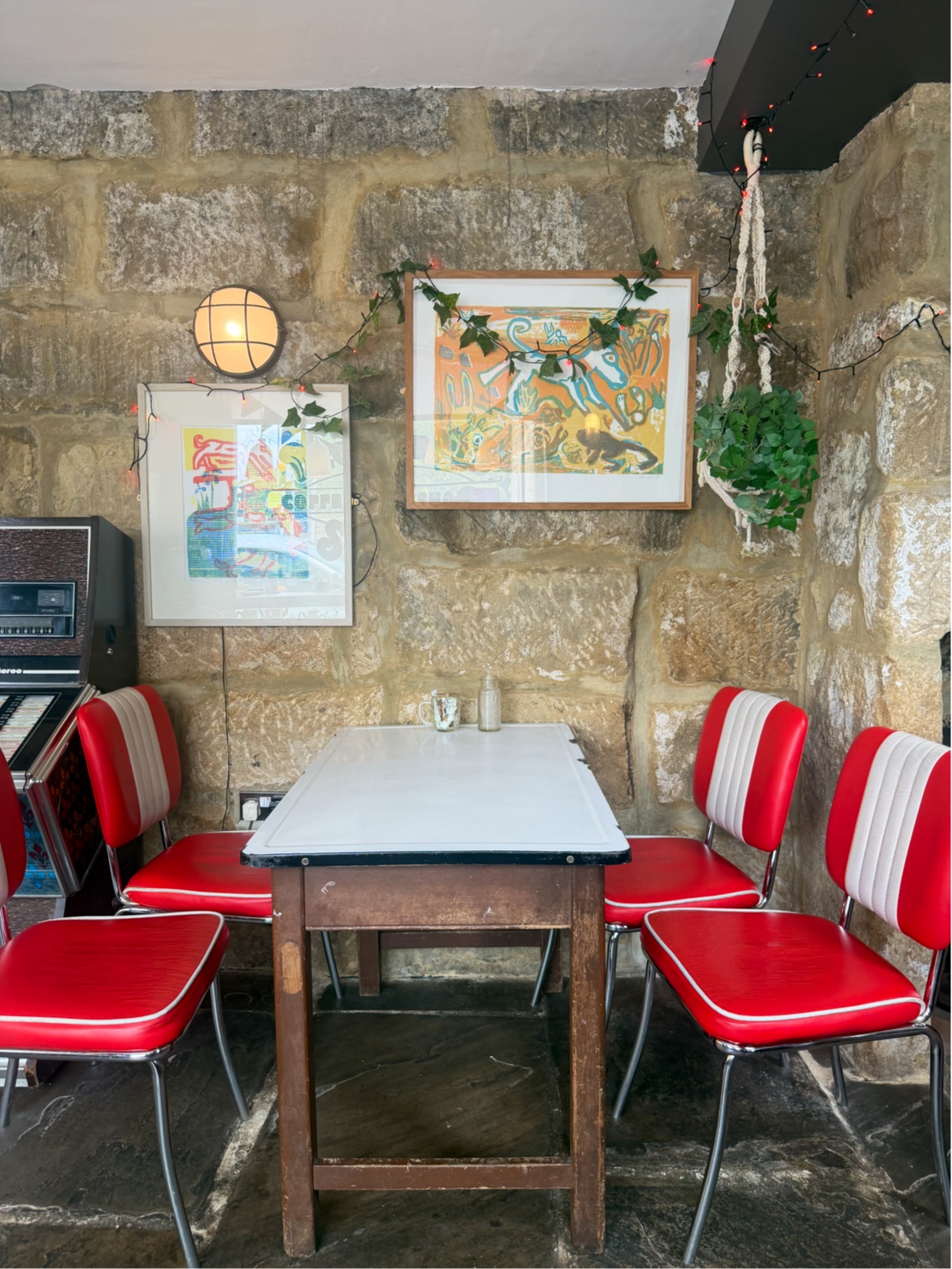 Red and white cafe chairs beside the jukebox at Bloomfield Square