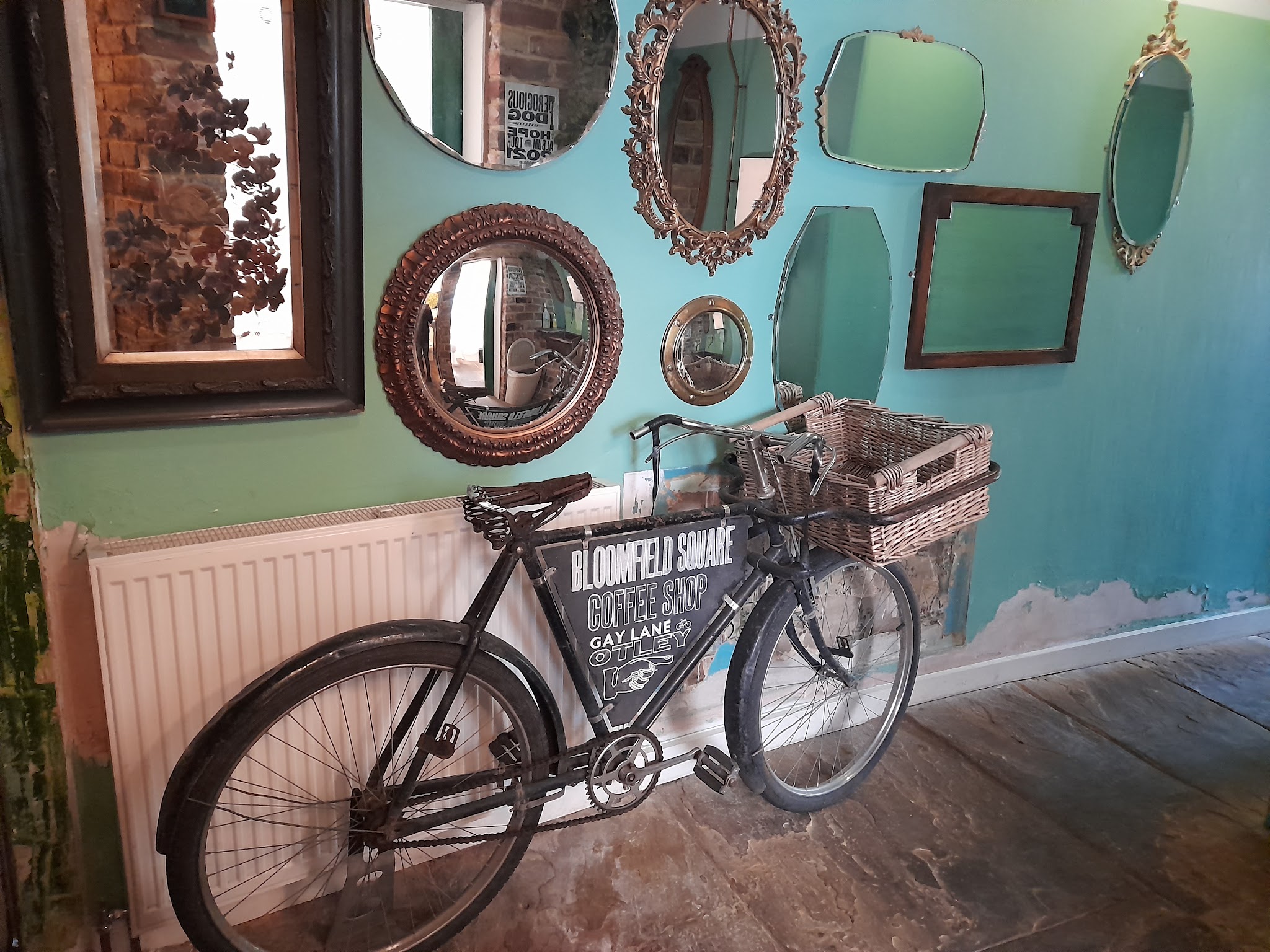 Vintage bicycle with Bloomfield Square sign beneath a collection of mirrors